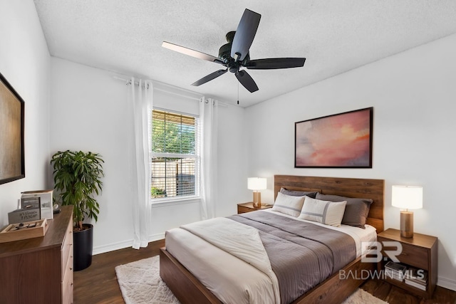 bedroom featuring baseboards, a ceiling fan, dark wood-type flooring, and a textured ceiling