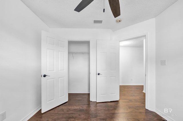 unfurnished bedroom featuring visible vents, dark wood-type flooring, a closet, baseboards, and ceiling fan