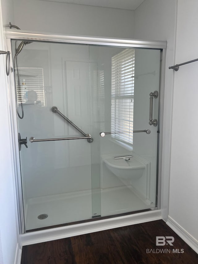 full bathroom featuring baseboards and a shower stall