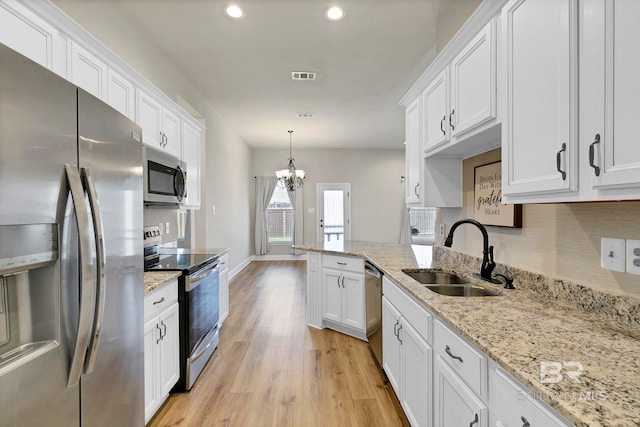 kitchen with visible vents, a sink, white cabinetry, stainless steel appliances, and light wood-type flooring