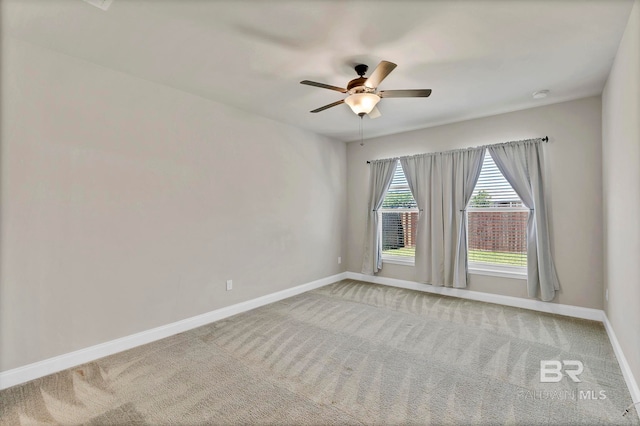 empty room with light carpet, baseboards, and a ceiling fan