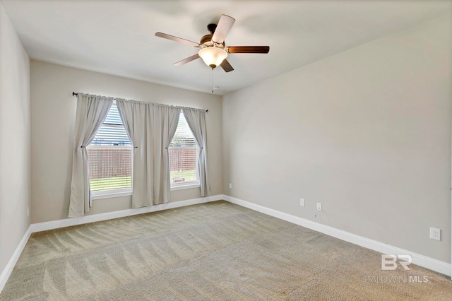 spare room with baseboards, ceiling fan, and carpet floors