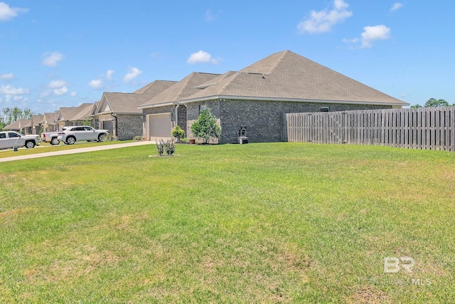 view of side of property with a garage, a yard, fence, brick siding, and driveway