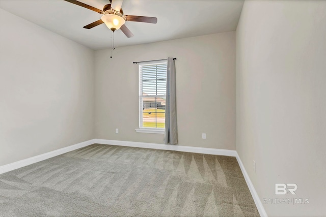 carpeted spare room with baseboards and a ceiling fan