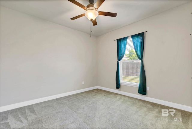spare room with ceiling fan, carpet, and baseboards