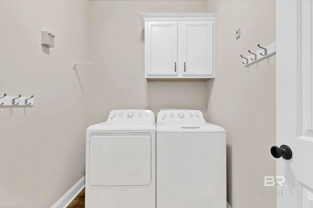 washroom with washing machine and clothes dryer, cabinet space, and baseboards
