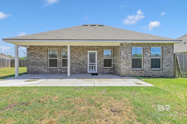 back of property with a yard, fence, a patio, and brick siding
