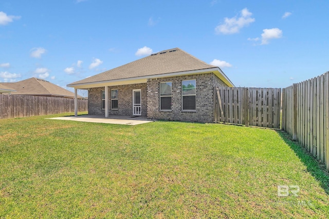back of house featuring a patio, brick siding, a lawn, and a fenced backyard