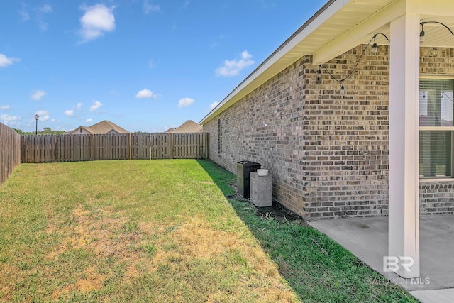 view of yard with a fenced backyard, a patio, and central air condition unit