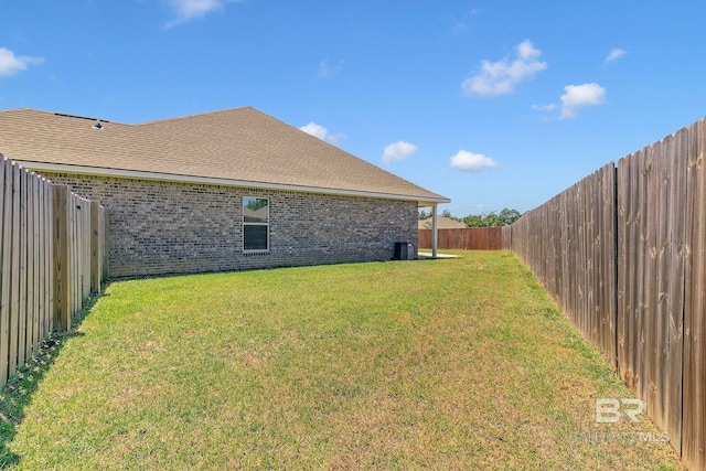 view of yard featuring a fenced backyard and central AC