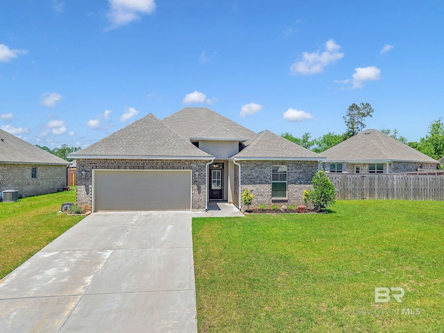 view of front of property with a front yard, brick siding, fence, and a garage