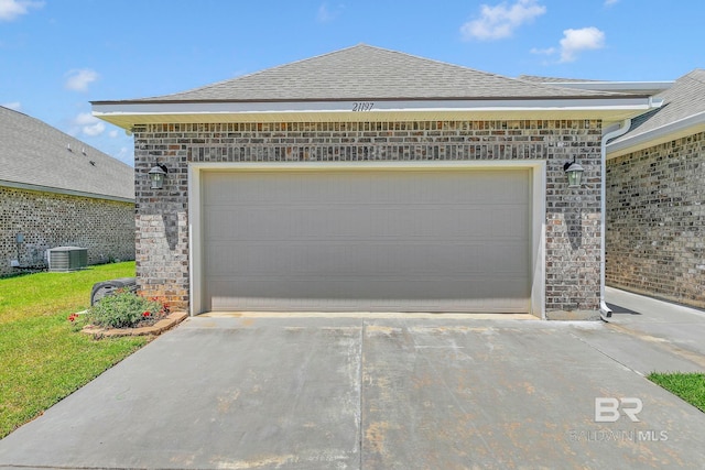 garage featuring central air condition unit and driveway
