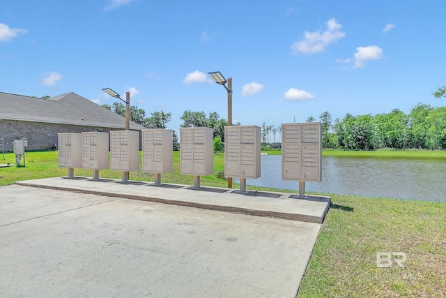 surrounding community with a water view and mail area