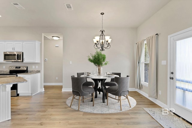 dining space with baseboards, a notable chandelier, visible vents, and light wood-type flooring
