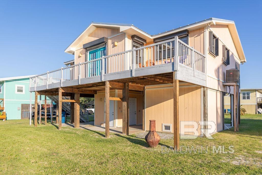 326 W 3rd Ave, Gulf Shores, AL 36542 - back of house with a wooden deck, a lawn, a carport, and stairway