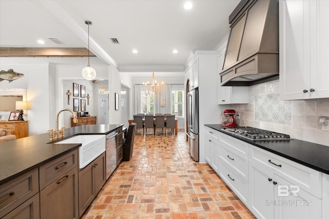 kitchen with stainless steel appliances, hanging light fixtures, sink, and white cabinets