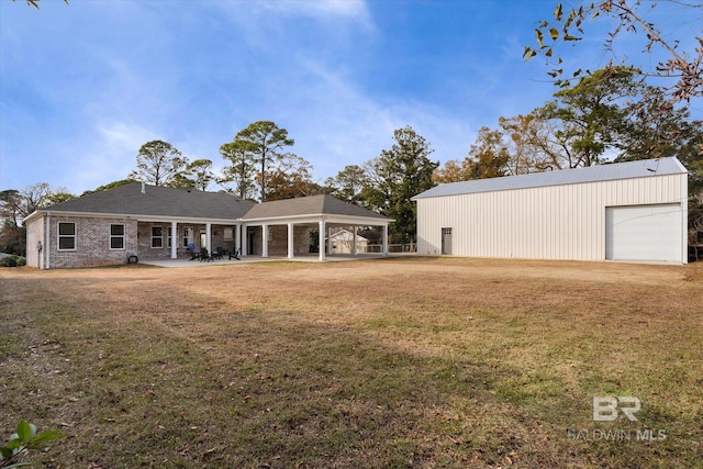 back of property with a garage, an outdoor structure, a yard, and a carport