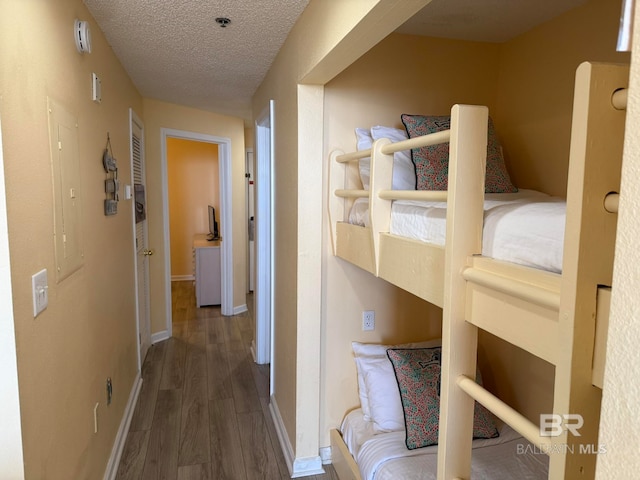 bedroom with a textured ceiling and dark hardwood / wood-style floors