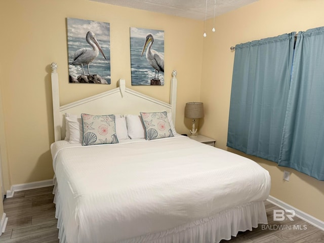 bedroom featuring hardwood / wood-style flooring and a textured ceiling