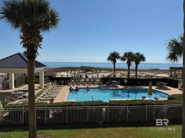 view of pool with a patio and a water view