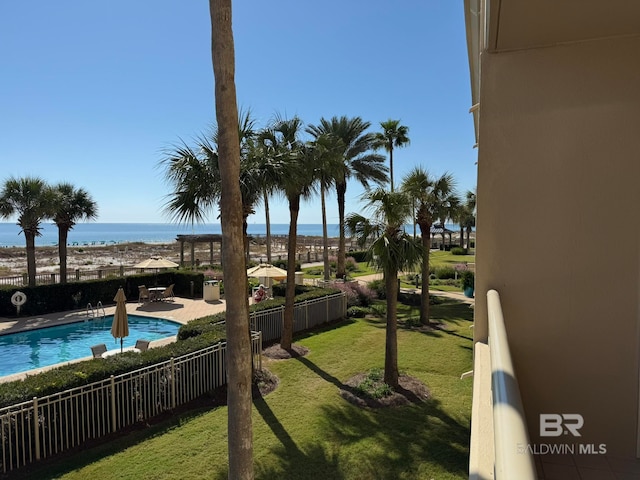 view of yard featuring a water view, a patio area, and a community pool