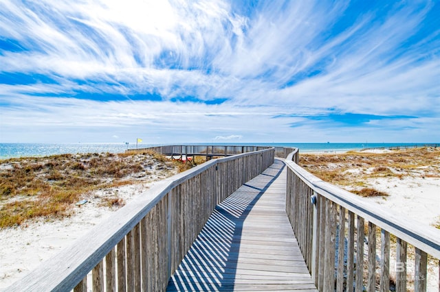 view of home's community featuring a water view and a beach view