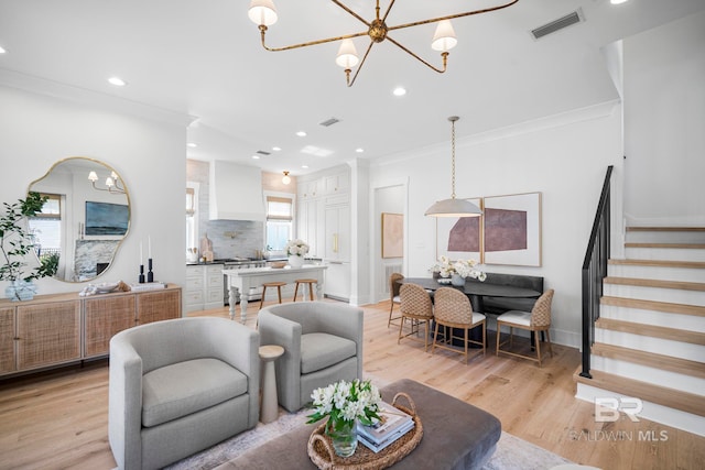 living room with light wood-type flooring, a wealth of natural light, and crown molding