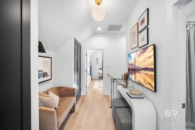 corridor featuring vaulted ceiling and light hardwood / wood-style floors