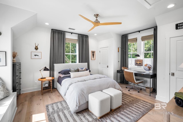 bedroom with light wood-type flooring, vaulted ceiling, multiple windows, and ceiling fan