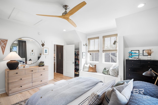 bedroom featuring light hardwood / wood-style flooring, vaulted ceiling, and ceiling fan