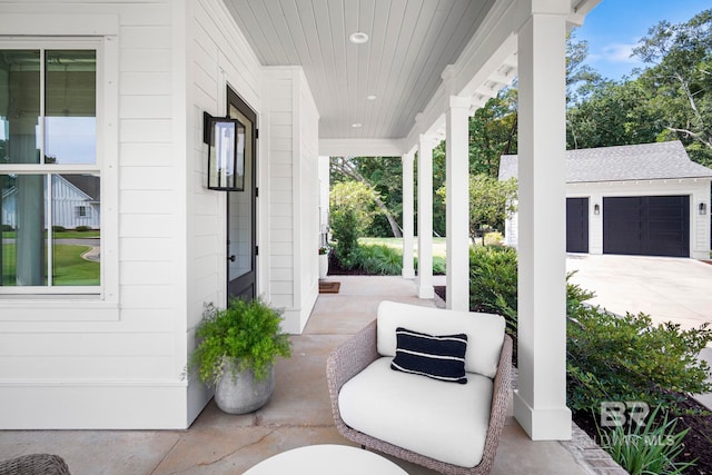 view of patio / terrace featuring a porch and a garage