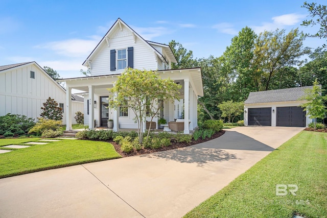 view of front facade featuring an outdoor structure, a garage, a porch, and a front lawn