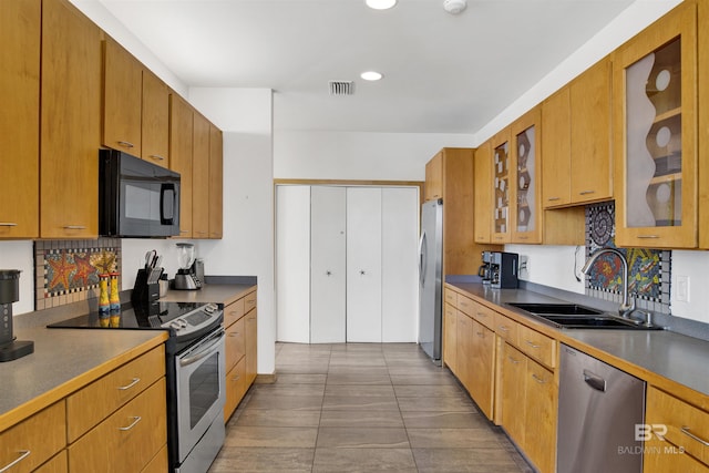 7166 Sharp Reef, Pensacola, FL 32507 - kitchen with appliances with stainless steel finishes, glass insert cabinets, dark countertops, recessed lighting, and brown cabinets