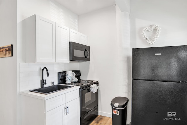 7166 Sharp Reef, Pensacola, FL 32507 - kitchen with black appliances, decorative backsplash, light countertops, white cabinets, and light wood finished floors