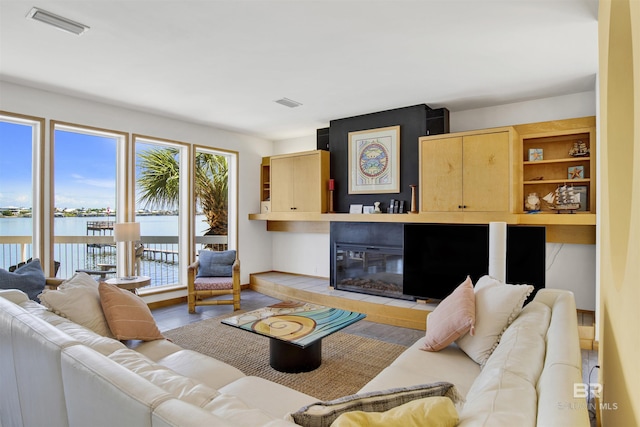7166 Sharp Reef, Pensacola, FL 32507 - living area featuring a fireplace, a water view, and light wood-style flooring