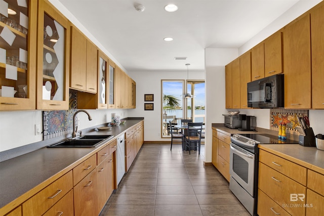 7166 Sharp Reef, Pensacola, FL 32507 - kitchen with stainless steel appliances, recessed lighting, glass insert cabinets, decorative backsplash, and decorative light fixtures