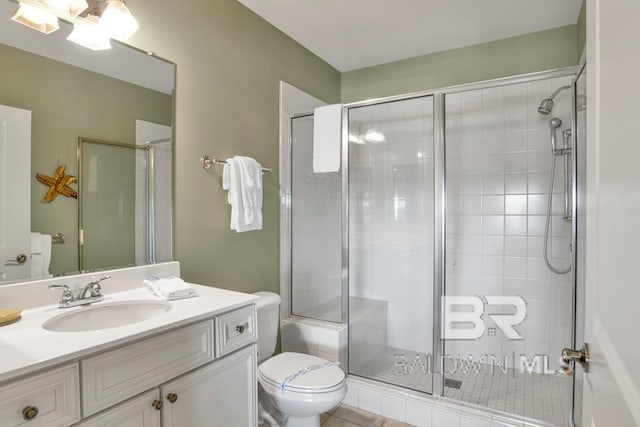 bathroom featuring tile patterned flooring, vanity, toilet, and walk in shower