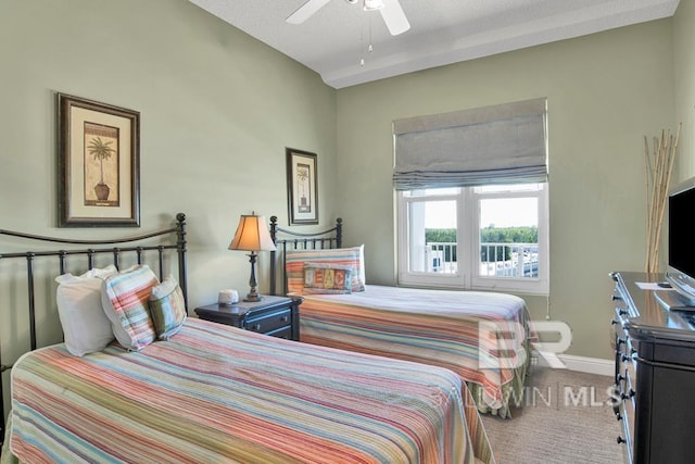 carpeted bedroom featuring ceiling fan and a textured ceiling