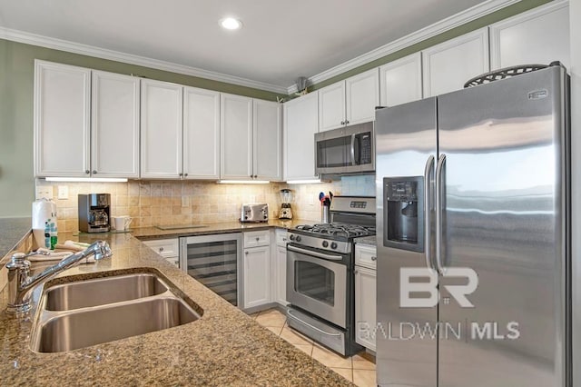 kitchen with white cabinetry, sink, beverage cooler, dark stone countertops, and appliances with stainless steel finishes