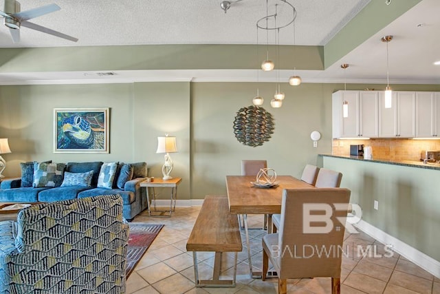 tiled dining area featuring ceiling fan, a textured ceiling, and ornamental molding