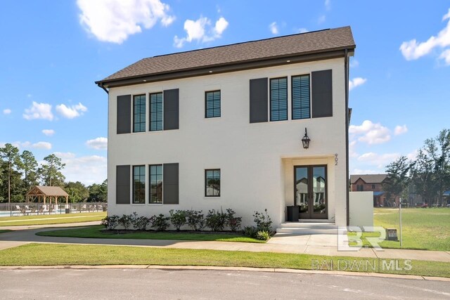 902 Inlet Cir, Gulf Shores, AL 36542 - view of front of property with french doors, roof with shingles, a front yard, and stucco siding
