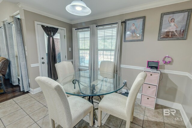 dining room featuring crown molding and light tile patterned floors