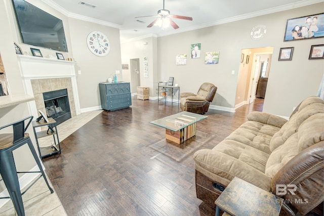 living room featuring a fireplace, crown molding, ceiling fan, and hardwood / wood-style floors