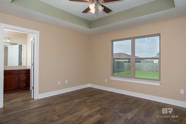 211 Lakefront Cir, Summerdale, AL 36580 - unfurnished room featuring dark wood-style floors, a raised ceiling, a ceiling fan, and baseboards