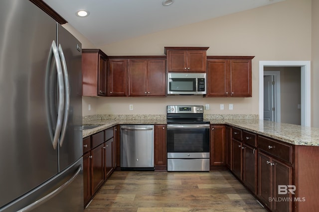 211 Lakefront Cir, Summerdale, AL 36580 - kitchen featuring appliances with stainless steel finishes, vaulted ceiling, dark wood finished floors, a peninsula, and light stone countertops