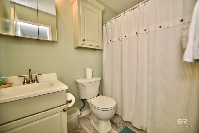 bathroom featuring toilet, hardwood / wood-style floors, and oversized vanity