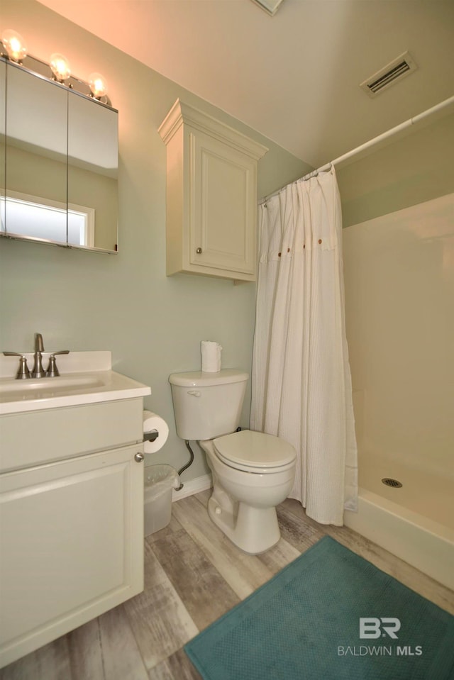 bathroom featuring vanity, curtained shower, hardwood / wood-style floors, and toilet