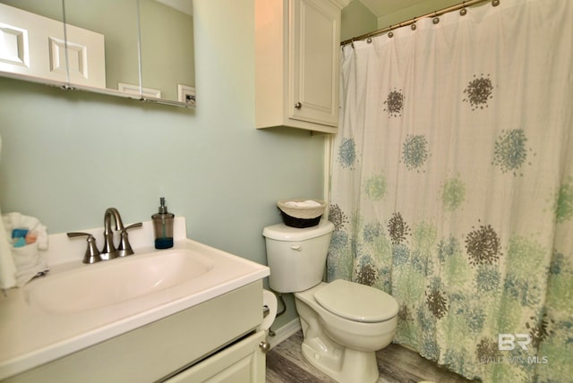 bathroom with toilet, large vanity, and hardwood / wood-style flooring