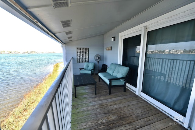 balcony featuring a water view and an outdoor living space