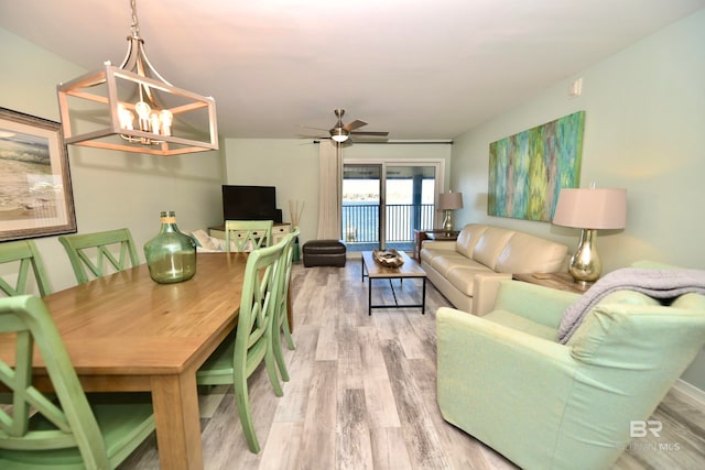 dining room with light hardwood / wood-style floors and ceiling fan with notable chandelier